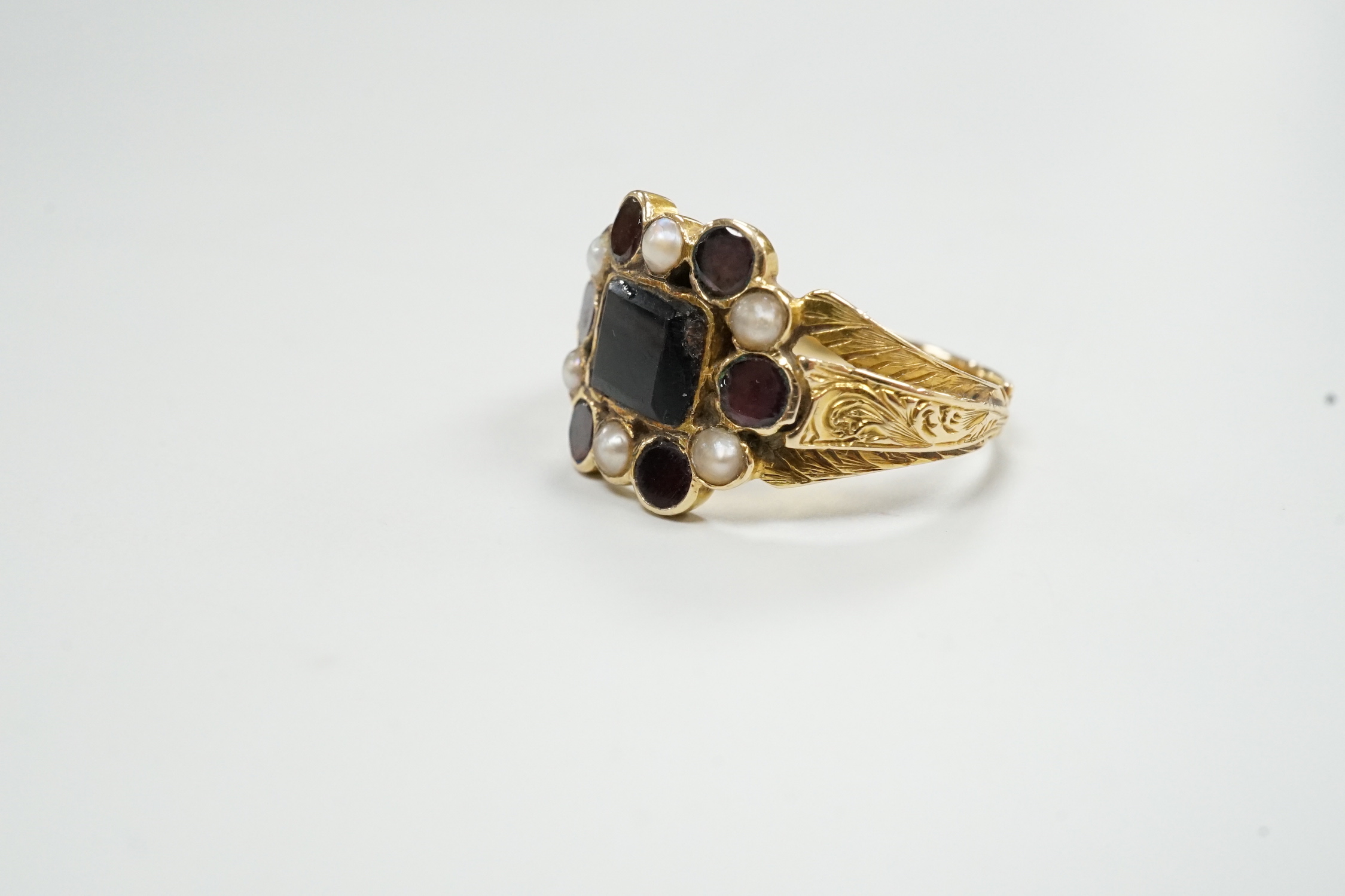 A George yellow metal, garnet and seed pearl cluster set mourning ring, with inscription dated 1799, size L, gross weight 2.7 grams.